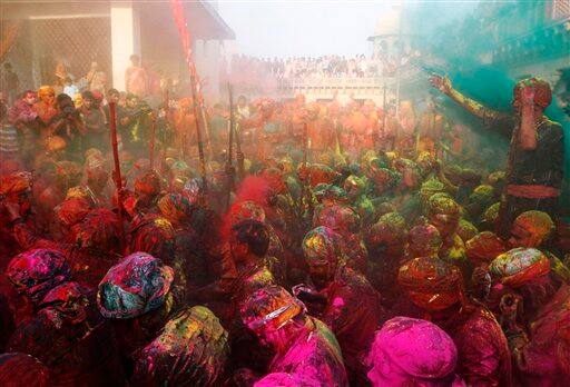 Indian villagers smear themselves with colors as they celebrate Holi festival in Nandgaon, near Mathura.