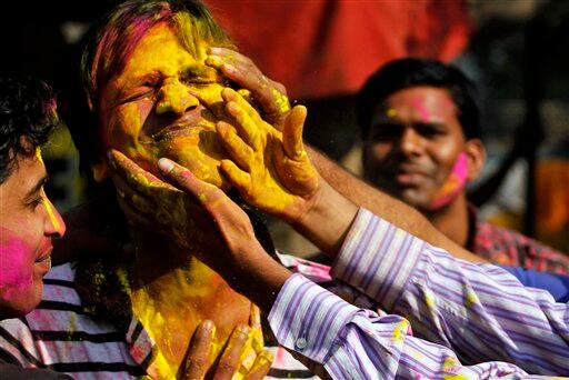 Students smear each other's face with colored powder during Holi festivities in Allahabad.