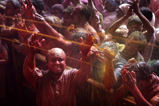 Hindu devotees colored by powder thrown while celebrating 