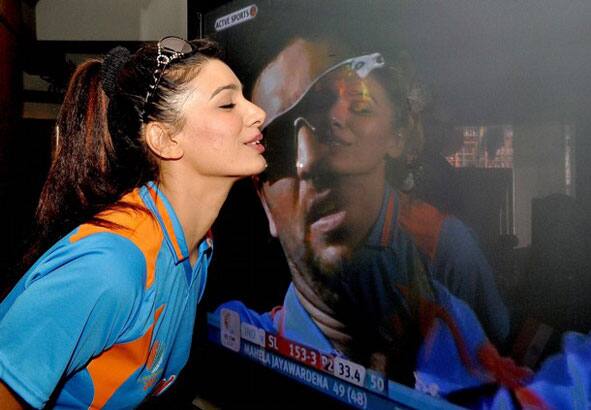 Indian Bollywood actress Mink Brar kisses a television screen showing an image of Indian cricketer Yuvraj Singh during the Cricket World Cup final match between India and Sri Lanka in Mumbai.