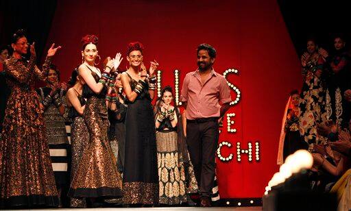 Models applaud after a presentation by Sabyasachi Mukherjee, center right, at the India Fashion Week in New Delhi.