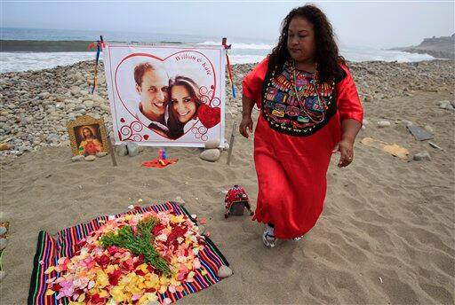 A Peruvian shaman stands by a photo of Britain's Prince William and Kate Middleton during a ritual to send good vibes to their royal wedding on La Herradura beach in Lima, Peru.