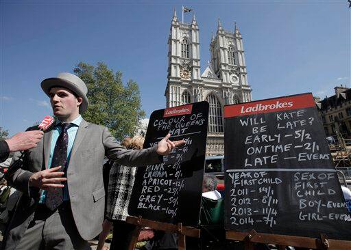 A man from a betting office displays the odds related to the upcoming royal wedding, across the road from the Westminster Abbey in central London.