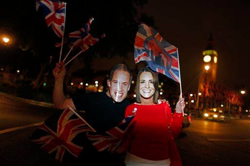 Graham Archer of Essex, left, and Kate Jackson of Brighton, right, cheer along the Royal Wedding route close to the Houses of Parliament in London.