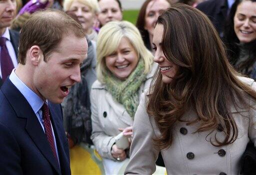 Britain's Prince William and Kate Middleton prepare to flip pancake at a display by the charity Northern Ireland Cancer Fund for Children outside the City Hall in Belfast.