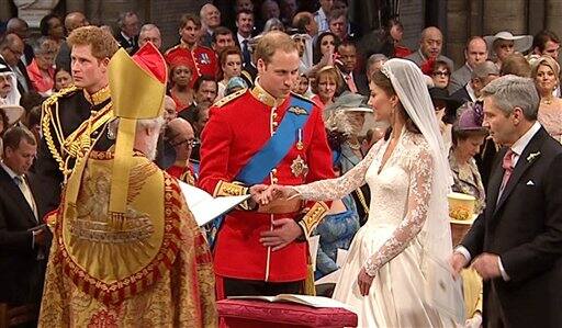 Britain's Prince William, center left, takes the hand of his bride, Kate Middleton, as they stand at the altar at Westminster Abbey for the Royal Wedding.