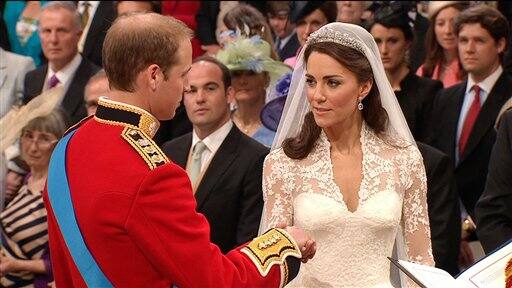 Britain's Prince William, left, takes the hand of his bride, Kate Middleton, as they stand at the altar at Westminster Abbey.