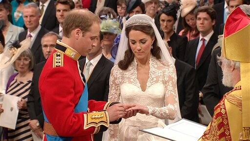 Britain's Prince William, left, places the ring on the finger of his bride, Kate Middleton, as they stand at the altar at Westminster Abbey.