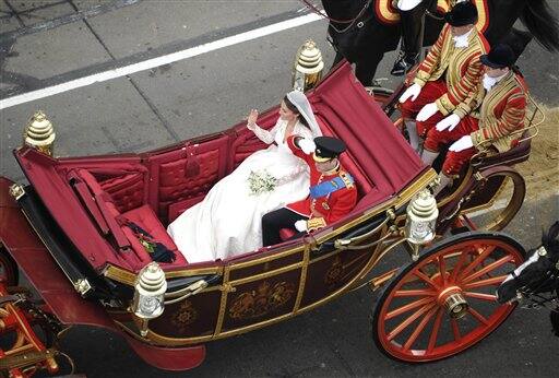 Britain's Prince William and Kate, the Duchess of Cambridge, wave as they travel in the 1902 State Landau carriage along the processional route to Buckingham Palace.