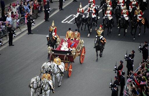 Britain's Prince William and his bride Kate, Duchess of Cambridge, travel in the 1902 State Landau carriage along the Processional Route to Buckingham Palace.