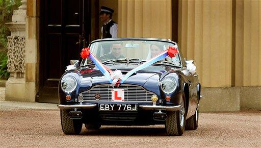 Britain's Prince William drives his wife, Kate, Duchess of Cambridge out of Buckingham Palace in London in his father Prince Charles' Aston Martin Volante sports car covered with bunting on their way to Clarence House after their wedding in nearby Westminster Abbey, in London.