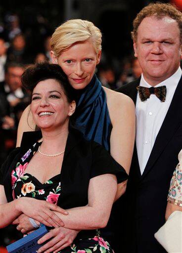 Actress Tilda Swinton, center, embraces director Lynne Ramsay next to actor John C. Reilly, right, on the red carpet of the screening of We Need to Talk About Kevin at the 64th international film festival, in Cannes.