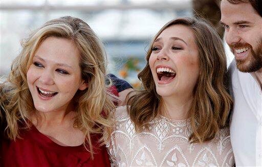 Actresses Louisa Krause, left, and Elizabeth Olsen pose with director Sean Durkin during a photo call for Martha Marcy May Marlene at the 64th international film festival, in Cannes.