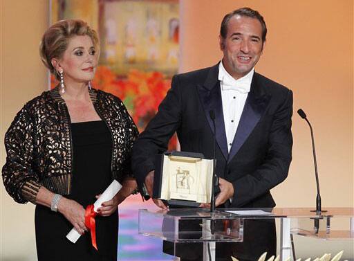 Actor Jean Dujardin, right, accepts the award for Best Actor for the film The Artist from actress Catherine Deneuve during the awards ceremony at the 64th international film festival, in Cannes.