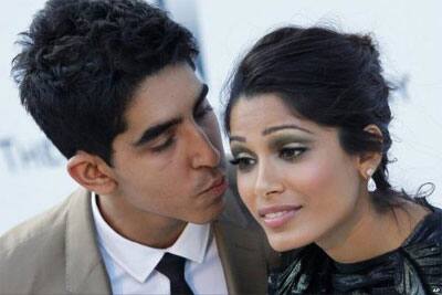 Dev Patel is about to kiss Freida Pinto during an event at Cannes.