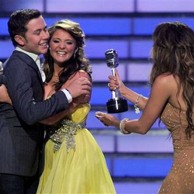 Winner Scotty McCreery, left, hugs finalist Lauren Alaina as Jennifer Lopez hand him his trophy at the 'American Idol' finale. 