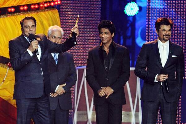 Actor Dharmendra (L) holds up his Life Time Achievement award during 2011 International Indian Film Academy (IIFA) awards at the Rogers Centre in Toronto.