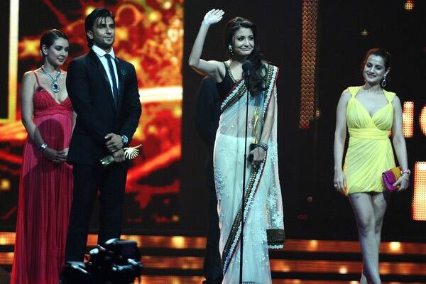 Actor Ranbir Singh (L) and actress Anushka Sharma (C) react as they receive the Hottest Pair of Bollywood award during the 2011 International Indian Film Academy (IIFA) awards at the Rogers Centre in Toronto.