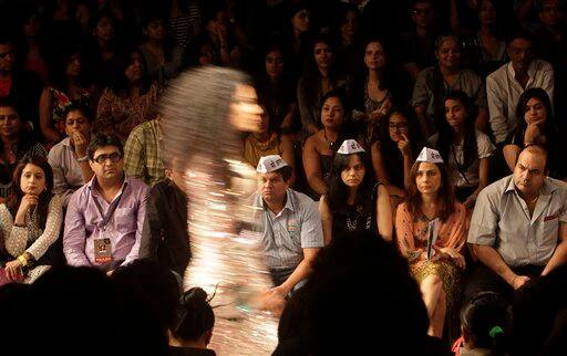 Supporters of anti-corruption activist Anna Hazare, wearing caps made popular by Hazare's anti-corruption movement, attend the Lakme Fashion Week.