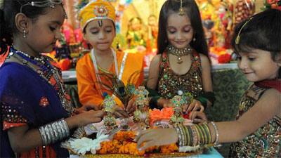 Indian children arrange decorations around miniature idols of Lord Krishna on the eve of the Janmasthami festival in Ahmedabad.