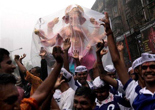 People wear caps, made popular by activist Anna Hazare's movement against corruption, as they transport an idol of elephant-headed Hindu God Ganesha for the upcoming Ganesh festival in Mumbai.