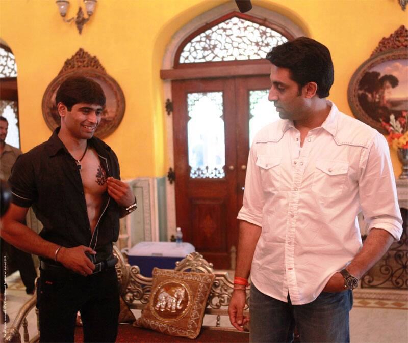 Nikhil Kateja, a fan of actor Ajay Devgn, shows his `Singham` tattoo to Bollywood star Abhishek Bachchan.