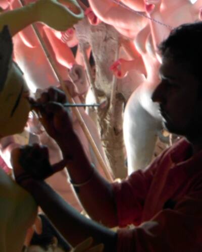 A painter paints eyes on a Lakshmi idol. Last minute preparations are being done on numerous Durga idols ahead of Durga Puja.