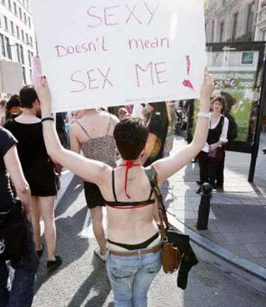 A woman protestor at Slutwalk in Brussels, walking with a board that reads, 