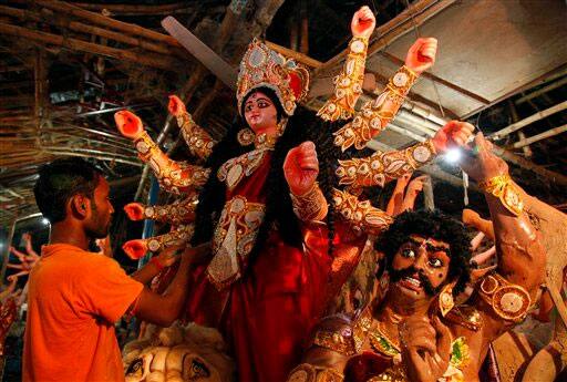 An Indian artist gives finishing touches to an idol of Hindu Goddess Durga, ahead of Durga puja festival in Allahabad.