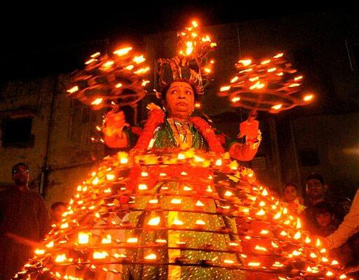 Indian woman Ushaben Dave, 64, wears dozens of oil lamps during celebrations for the festival of Navratri in Ahmedabad.