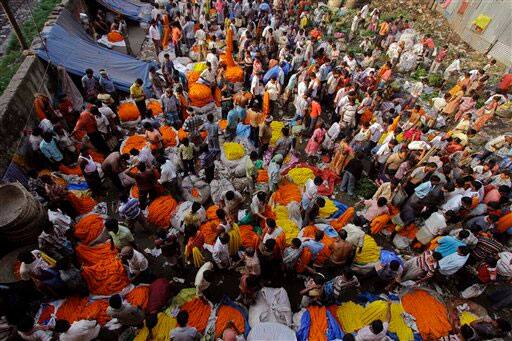 Indian vendors sell flower garlands at a wholesale market on the second day of Hindu festival Durga Puja in Kolkata.