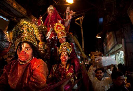 Indian youths dressed as Hindu gods ride on a cart during a procession ahead of Dussehra festival in New Delhi.