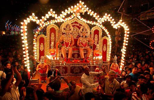 Indian artists dressed as Hindu God Rama, left, and his brother Lakshman sit on a tableau during a Dussehra festival procession in Allahabad.