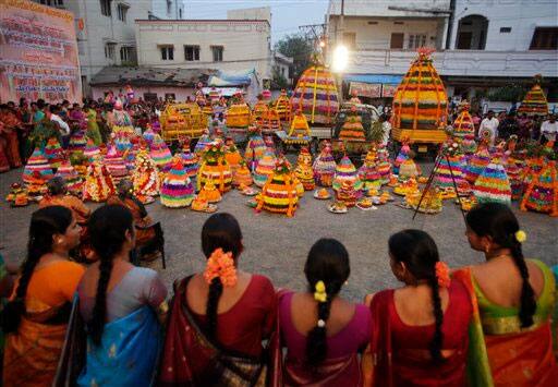 Hindu women dance around Bathukammas, floral arrangement representing the giver of life, during the Bathukamma festival dedicated to the Hindu goddess Gauri.