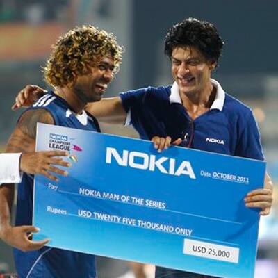 Mumbai Indians' player Lasith Malinga receives Man of the Series award from Shahrukh Khan after his team's win over Royal Challengers Bangalore in the Champions League Twenty20 cricket final match in Chennai.