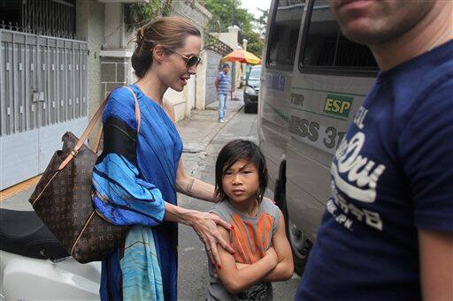 Angelina Jolie, left, and her adopted son Pax Thien get on a minivan to leave a Vietnamese restaurant in Ho Chi Minh City, Vietnam.