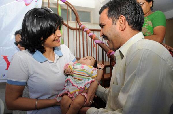 Bollywood celebrity and Cryo-Save India's brand ambassador, Mandira Bedi  interacts with a cancer affected baby and the father at Gujarat Cancer and Research Institute to mark Children's Day, in Ahmedabad.