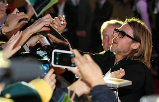 Brad Pitt signs autographs for fans on the red carpet for his latest film 