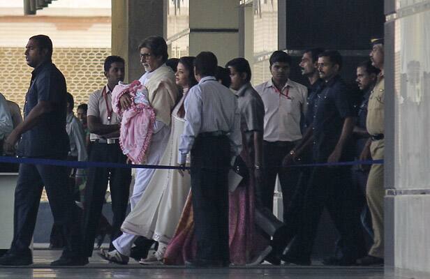 Amitabh Bachchan walks out of a hospital holding his grand-daughter and daughter of actress and former Miss World Aishwarya Rai Bachchan in Mumbai.