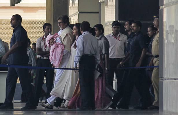 Amitabh Bachchan walks out of a hospital holding his grand-daughter and daughter of actress and former Miss World Aishwarya Rai Bachchan in Mumbai. 