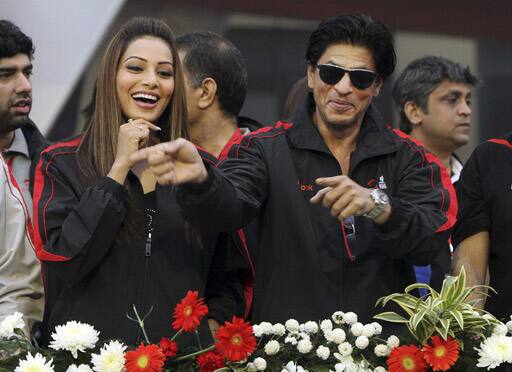 Bollywood actors Shah Rukh Khan , right, and Bipasha Basu laugh as they make an appearance at the start/finish area of the Airtel Delhi Half Marathon in New Delhi.