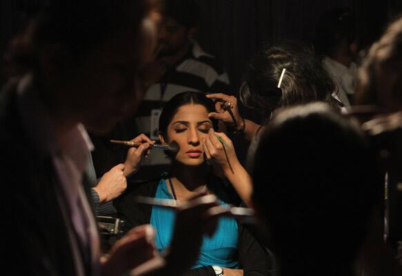 A Pakistani model has make up applied before a fashion show in Karachi.