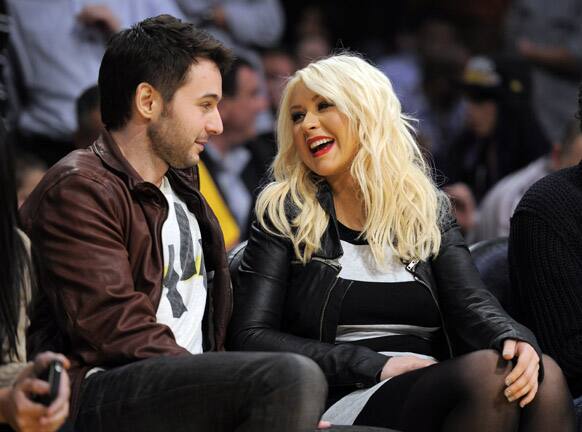 Christina Aguilera and Matt Rutler watch the Los Angeles Lakers play the Oklahoma City Thunder in their NBA basketball game in Los Angeles. 