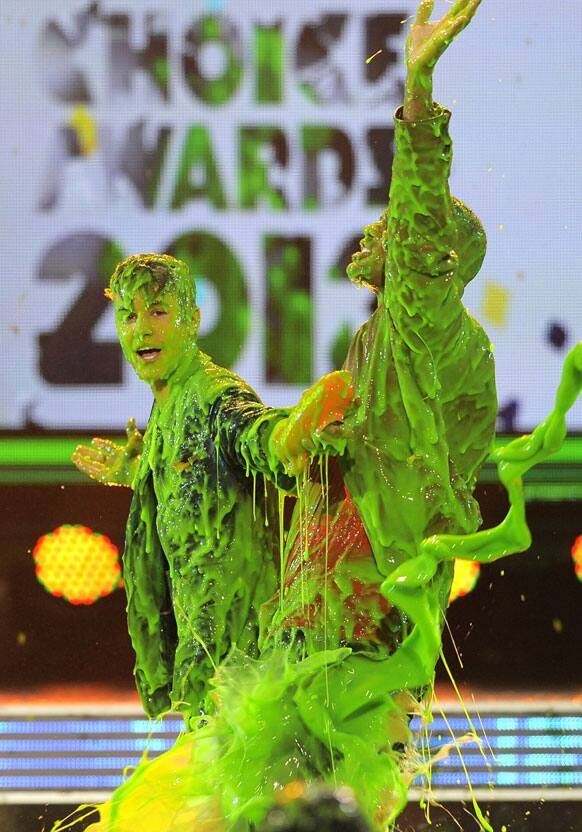 Justin Bieber, left, and host Will Smith get slimed after Bieber accepts the award for favorite male singer onstage at Nickelodeon's 25th Annual Kids' Choice Awards.