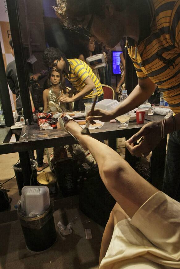 A Pakistani model has make up applied, during Fashion Week, in Karachi.