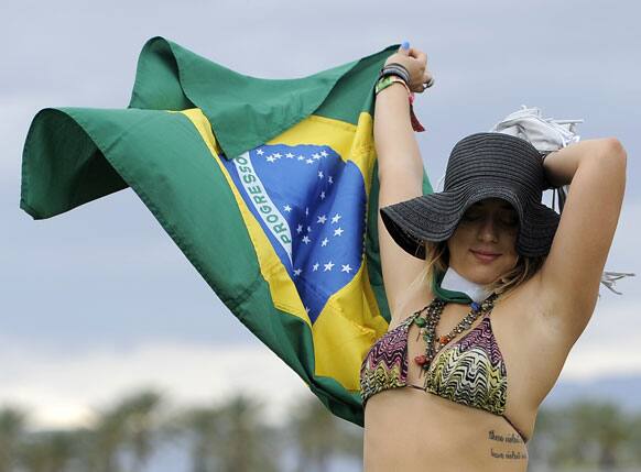 Marjorie Tavares, of Rio de Janeiro, Brazil, dances with a Brazilian flag during the first weekend of the 2012 Coachella Valley Music and Arts Festival.