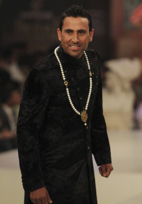 Pakistani test cricketer Younis Khan presents a creation during Bridal Couture Week in Karachi, Pakistan.