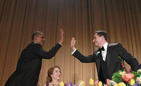 President Barack Obama high-fives late-night comic Jimmy Kimmel as Caren Bohan, a Reuters journalist and president of the White House Correspondents' Association looks on during the White House Correspondents' Association Dinner.