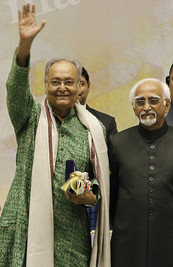 Bengali film and theater actor Soumitra Chatterjee, left, waves after receiving the Dadasahab Phalke Award for the year 2011, as Indian Vice President Hamid Ansari looks on, during the 59th National Film Award in New Delhi.