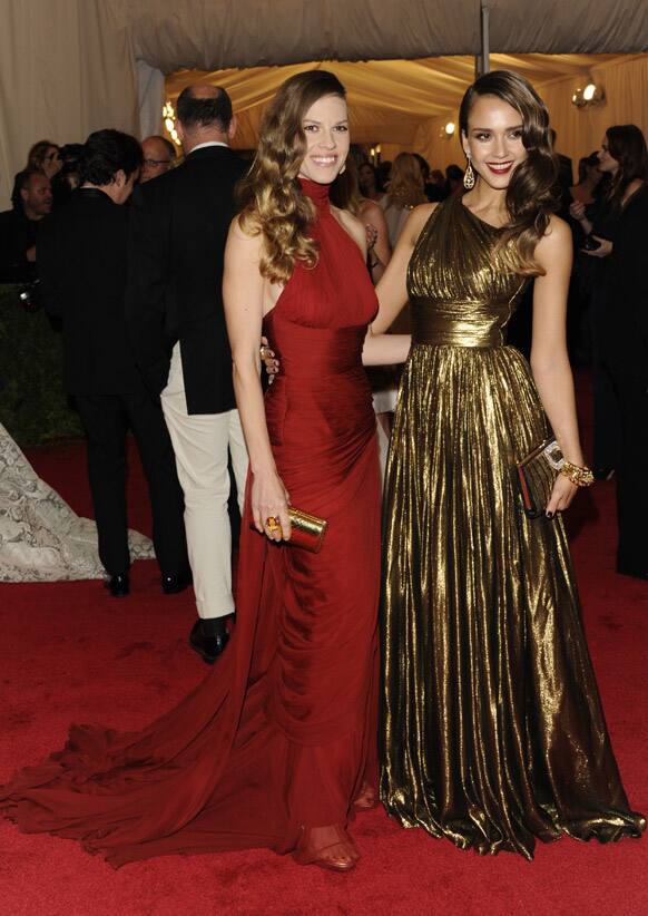 Hilary Swank, left, and Jessica Alba arrive at the Metropolitan Museum of Art Costume Institute gala benefit, celebrating Elsa Schiaparelli and Miuccia Prada, in New York.